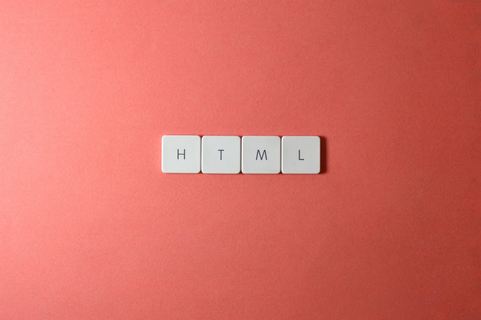 Four white tiles with black letters spelling 'HTML' are arranged in a horizontal line on a smooth, coral-colored surface. The tiles are evenly spaced, with clean and sharp edges, and the surface appea